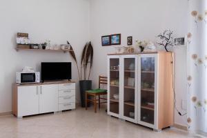 a living room with a white cabinet and a tv at Le Crapare in Muro Leccese +16 photos