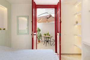 a bedroom with a red door leading to a table at cmv Salento in Marina di Pescoluse