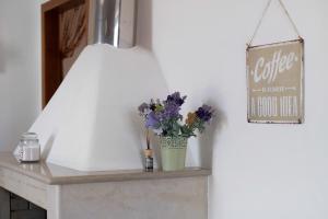 a vase of flowers on a mantle with a sign at Le Crapare in Muro Leccese