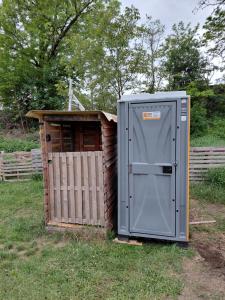 a outhouse with a door next to a fence at Bycicle camp - Český Bufík in Horní Počaply