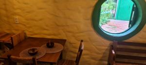 a room with two tables and a round window at Cabana Refúgio do Hobbit-Gramado @refugiodohobbit in Gramado