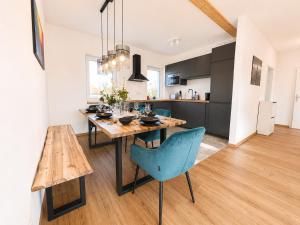 a kitchen and dining room with a wooden table and chairs at Dill Apartment Pleinfeld am Brombachsee III in Pleinfeld +20 photos