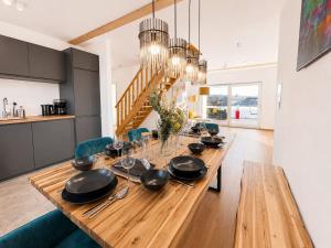 a dining room with a long wooden table with utensils at Dill Apartment Pleinfeld am Brombachsee III in Pleinfeld