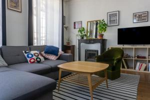 a living room with a couch and a table at Le Galois - Spacieux appartement en hypercentre de Blois in Blois