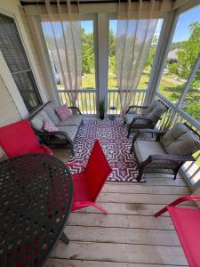 a screened in porch with chairs and tables at The Phoebe - 65 Butternut in Cherry Valley