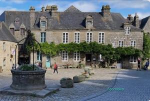 an old building with a fountain in front of it at Les mouettes rieuses in Telgruc-sur-Mer