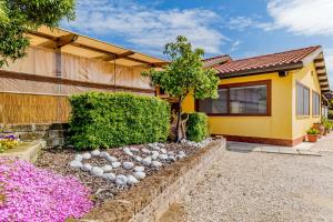 a house with a garden with rocks in front of it at Le Terre Di BAC in Borgo Montenero