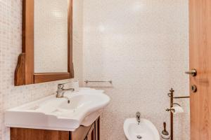 a white bathroom with a sink and a mirror at Le Terre Di BAC in Borgo Montenero