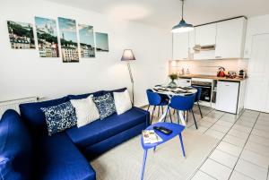 a living room with a blue couch and a table at T2 Cocon Prestige Lyonnais : Sécurité Commodités in Vénissieux