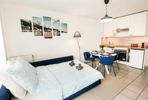 a bedroom with a bed and a table and a kitchen at T2 Cocon Prestige Lyonnais : Sécurité Commodités in Vénissieux