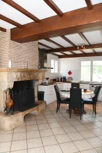 a kitchen with a fireplace and a table and chairs at Domaine familial, Le Parc de Gouts in Aiguillon