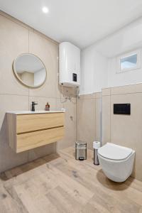 a bathroom with a toilet and a sink and a mirror at Appartement im Schloßhof in Rechnitz +9 photos