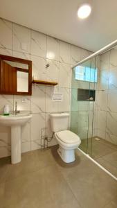 a bathroom with a toilet and a sink at Pousada Farol do Rosa in Praia do Rosa +22 photos