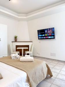 a bedroom with two beds and a tv on the wall at S'Olivare Posada - Apartments in Posada +10 photos