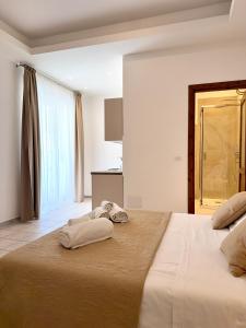a bedroom with a large bed with towels on it at S'Olivare Posada - Apartments in Posada