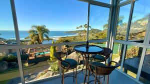 a view of the ocean from a room with windows at Pousada Farol do Rosa in Praia do Rosa