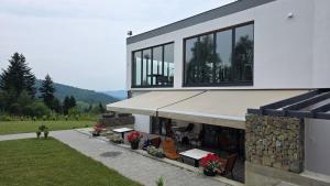 a house with windows and a patio with flowers at Zveniv Resort in Oryavchyk +18 photos