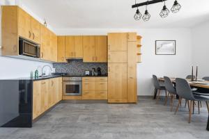 a kitchen with wooden cabinets and a table with chairs at Appartement im Schloßhof in Rechnitz