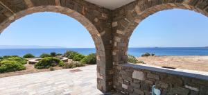 an archway in a building looking out at the ocean at Thea Studio Paros in Logaras