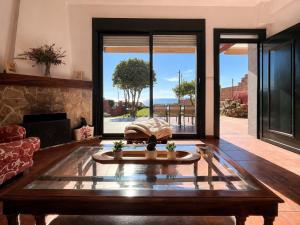 a living room with a table and a fireplace at Holibai Vila Santa Rita Vistas al mar cerca de Baiona in Oia