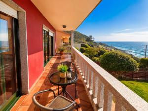 a balcony with a table and chairs and the ocean at Holibai Vila Santa Rita Vistas al mar cerca de Baiona in Oia