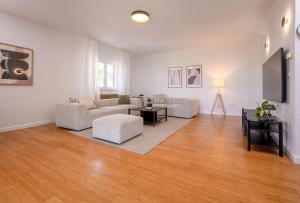 a living room with white furniture and a flat screen tv at Villa Botanica near Split - Heated Pool and Garden in Kučine