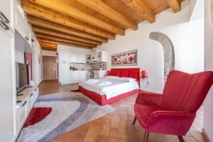 a bedroom with a red bed and a red chair at Happy Guest Apartments - Lake And Passion in Riva di Solto