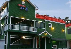 a green building with a sign on the side of it at Buan Floor Pension in Buan