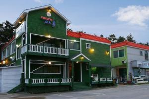 a green building with a sign on top of it at Buan Floor Pension in Buan