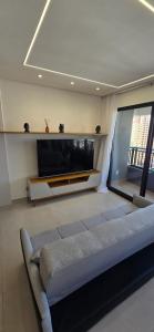 a living room with a couch and a flat screen tv at Opus Gyro Vaca Brava Designer in Goiânia