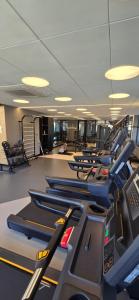 a gym with rows of treadmills and machines at Opus Gyro Vaca Brava Designer in Goiânia