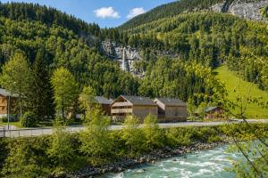 a lodge next to a river in a mountain at Eichen Lodge Mellau in Mellau