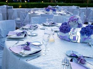 シルヴィ・マリーナにあるGrand Hotel Bertiの紫色の花と銀器が飾られた白いテーブル