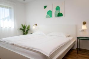 a large white bed in a white bedroom at Start Point Apartments in Žirovnica