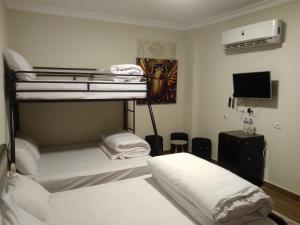 two bunk beds in a room with a tv at The 5 Inn - Rooftop Pyramids View in Cairo