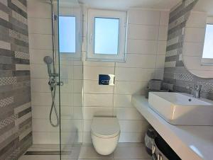 a bathroom with a shower and a toilet and a sink at Casa Thea in Archangelos +19 photos