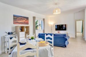 a living room with a blue couch and a table at Villa Brisa de Gairia in Antigua