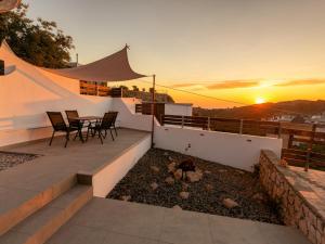 a balcony with a table and chairs and the sunset at Casa Thea in Archangelos