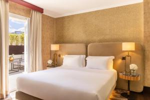 a bedroom with a large bed and a balcony at Tivoli Palazzo 1880 Lecce Hotel in Lecce