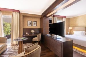 a hotel room with a bed and a flat screen tv at Tivoli Palazzo 1880 Lecce Hotel in Lecce