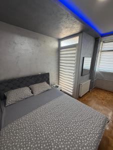 a bedroom with a bed with a blue light above it at Play Apartman Obrenovac in Obrenovac