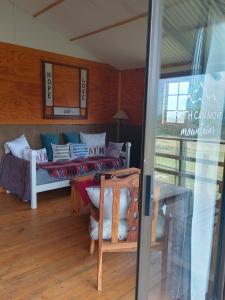 a living room with a couch and a table with pillows at Faith Cabin in Waterval-Onder