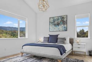 a white bedroom with a bed and two windows at Chardonnay Getaway in Glen Ellen
