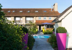a house with a swimming pool in a yard at Country House Duinhof in De Haan