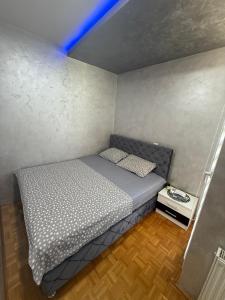 a small bed in a small room with a ladder at Play Apartman Obrenovac in Obrenovac