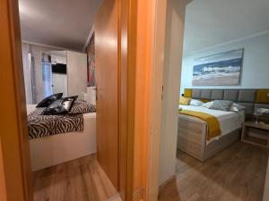 a small room with two beds and a hallway at Apartment relax jacuzzi terrace with sea view in Brela