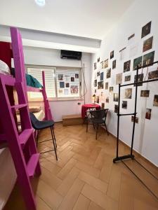 a room with a purple ladder and chairs and a table at Maison D'artiste Boutique Hostel in Tirana