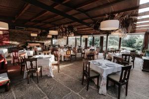 a restaurant with white tables and chairs and windows at Casa Grande Do Bachao in Santiago de Compostela