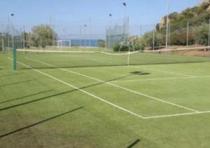 a tennis court with a net on top of it at Villa Beafe' Ogliastra con piscina in Tertenìa