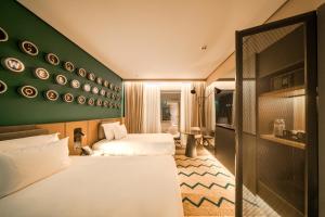 a hotel room with two beds and a green wall at The NINE Lifestyle Experience in Tunis +92 photos